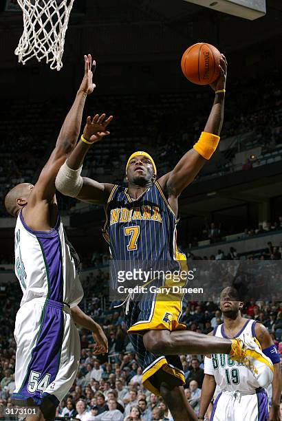 Jermaine O'Neal of the Indiana Pacers leaps inside for a layup against Brian Skinner of the Milwaukee Bucks as Damon Jones looks on during the game...
