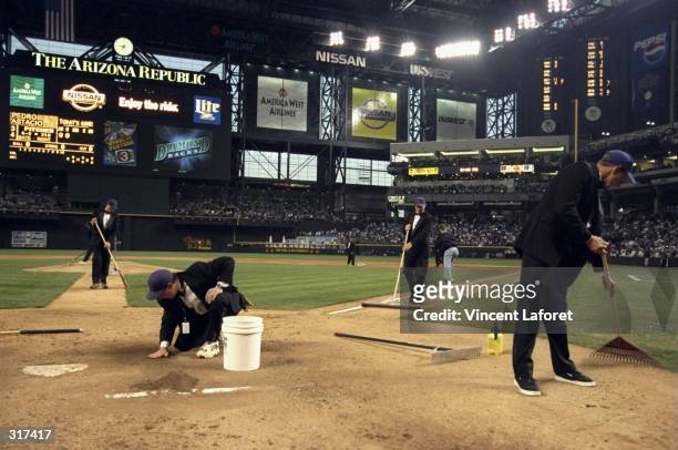 General view of groundskeepers in tuxedos working on the field during the opening day game between the Arizona Diamondbacks and the Colorado Rockies...