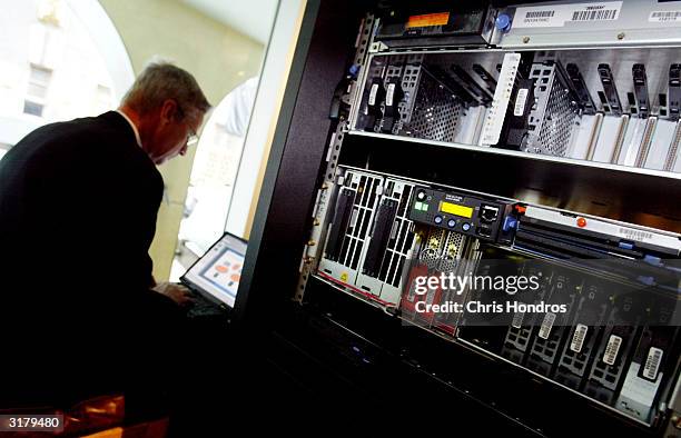 Man works on a laptop in front of an IBM server March 31, 2004 in New York City. International Business Machines Corp unveiled a strategy March 31 to...