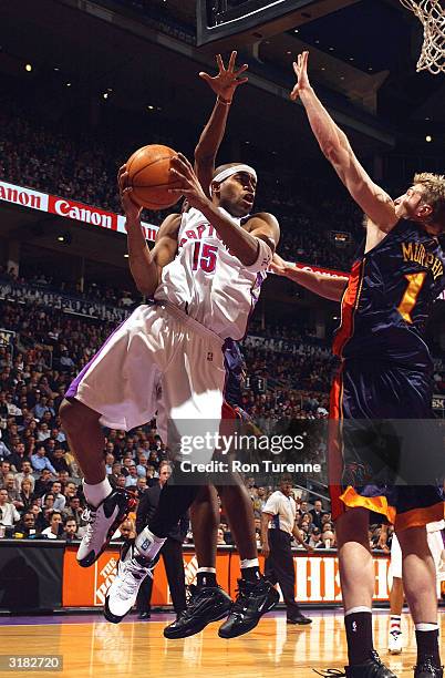 Vince Carter of the Toronto Raptors looks to pass after being cut off along the baseline by Troy Murphy of the Golden State Warriors on March 31,...