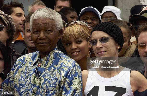 South African politician Nelson Mandela and British singer Annie Lennox attend a press conference outside his former prison cell on Robben Island...