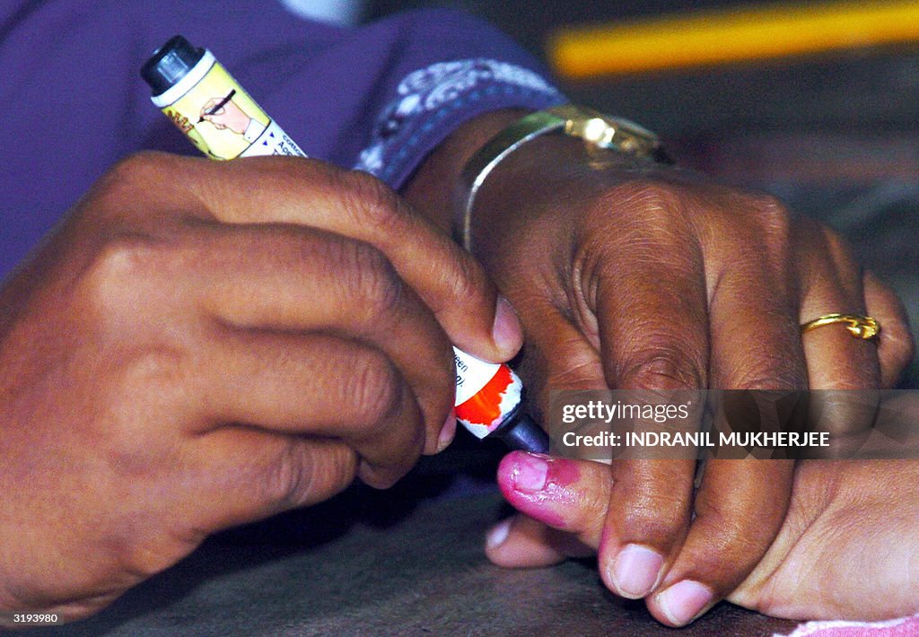 A Sri Lankan election official (L) marks