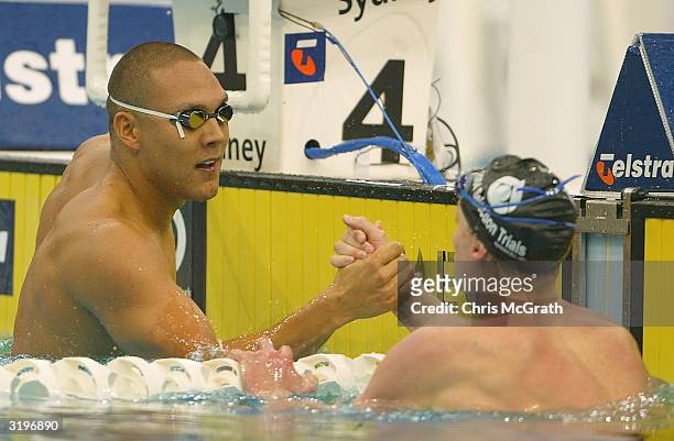 Geoff Huegill shakes hands with Justin Norris after the Men's 100m butterfly final during finals on day seven of the 2004 Telstra Olympic Team...