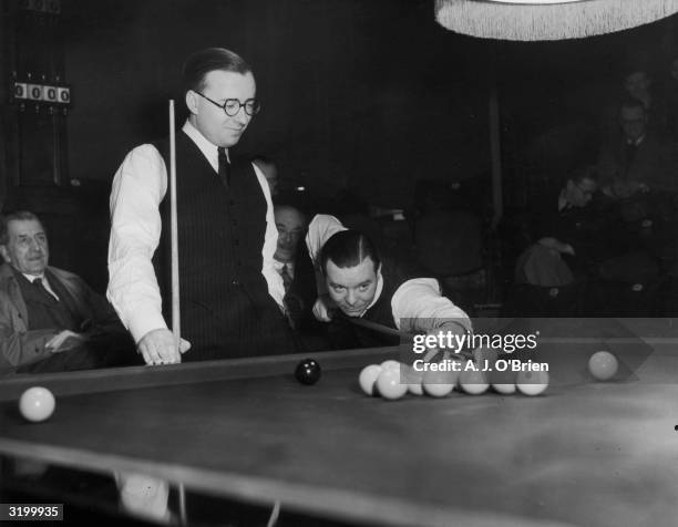 Snooker champion, Joe Davis taking a shot watched by his younger brother Fred at the World Snooker Championship semi-finals at Thornton's in...