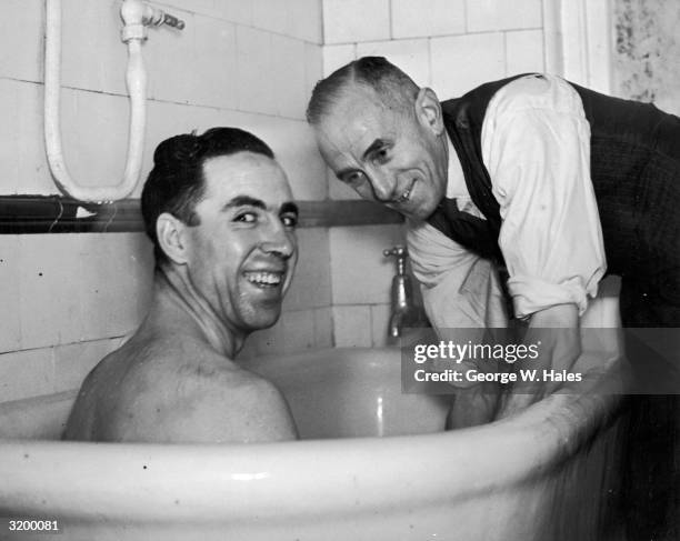 West Ham wing half Norman Corbett having a knee massage from trainer Billy Moore. The West Ham team are visiting salt baths in Southend as...