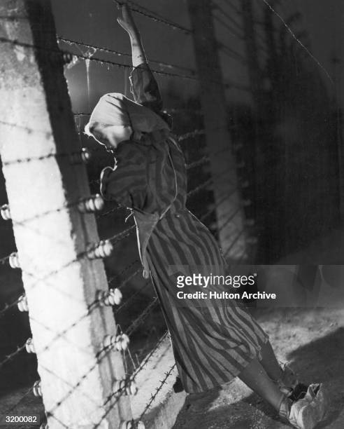 Woman clinging to the barbed wire fence at Auschwitz in a scene from Wanda Jakubowska's 'Ostatni Etap' . The film was based on Jakubowska's own...