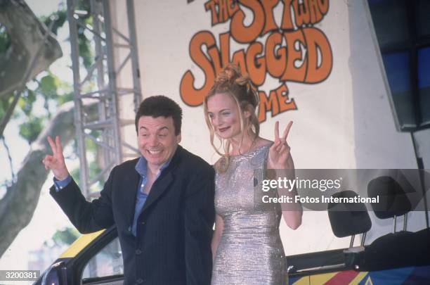 Actors Mike Myers and Heather Graham flashing the peace/victory sign during a promotional shoot for the film Austin Powers: The Spy Who Shagged Me at...