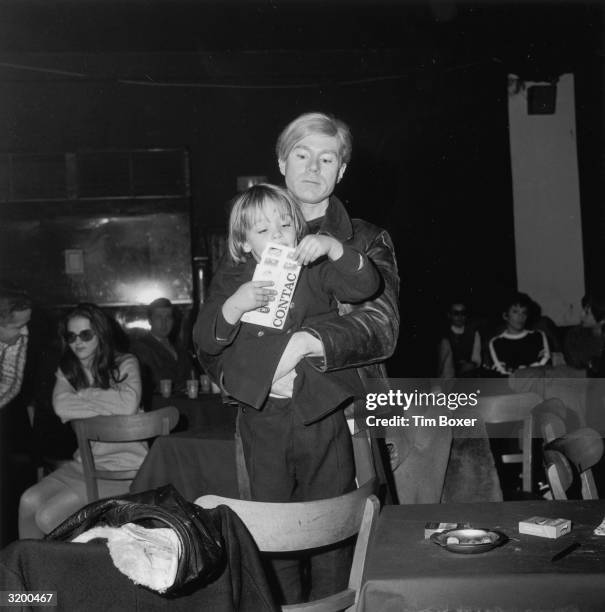 American artist Andy Warhol holds Ari P?ffgen, son of singer Nico, who was performing with the rock group The Velvet Underground during a 'Freakout'...