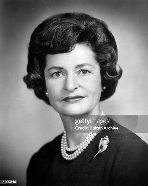 Headshot of Vice President Lyndon B. Johnson's wife, Lady Bird, wearing a pearl necklace and a rose brooch on her sweater.