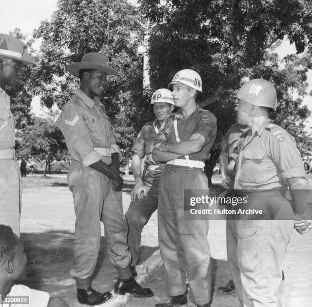 Swedish troops, part of the United Nations peacekeeping forces in the Republic of Congo, stand talking with Nigerian soldiers at Kano airport,...