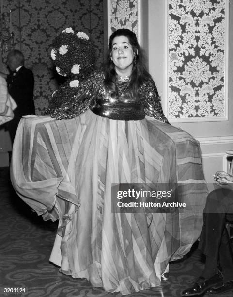 Full-length image of American singer Mama Cass Elliot curtseying in a floor-length gown at the Academy Awards, Hollywood, California.