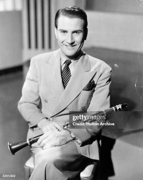 American jazz musician and bandleader Artie Shaw holds his clarinet and poses for a portrait, circa 1935.