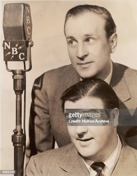 Headshot promotional portrait of American comedy team Abbott and Costello, Bud Abbott and Lou Costello, posing next to an NBC radio microphone.