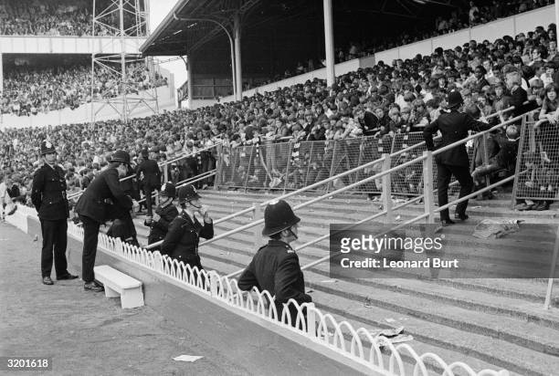 At a football match at White Hart Lane between Tottenham and Liverpool police take precautionary measures to prevent hooligan incidents which have...