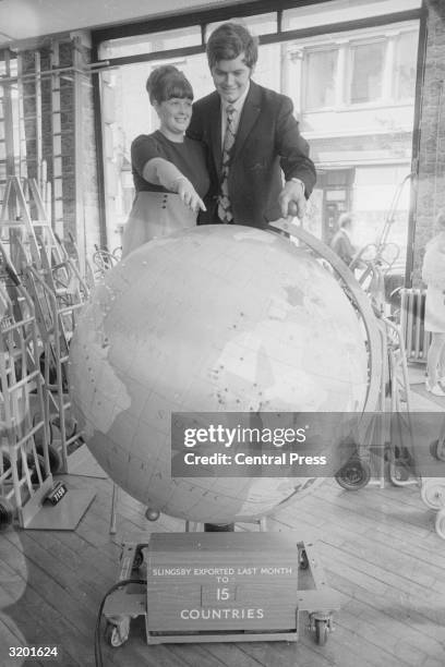 Malcolm Rees and his wife looking at a globe to choose a holiday destination after winning the Littlewoods pool.