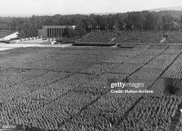 High-angle view of the Nazi Party Congress, with 25,000 people standing in the arena before the German Fuhrer Adolf Hitler and his Third Reich party...