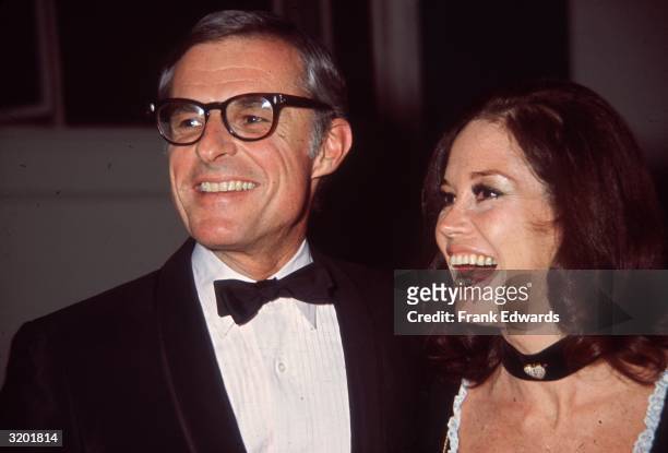 Headshot of American actor and comedian Mary Tyler Moore smiling as she stands next to her husband, Grant Tinker, at a party at Chasen's nightclub,...