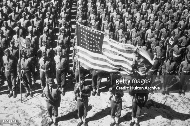 Group view of the soldiers of the 41st Corps of Engineers, an African-American army battalion, standing in formation and holding the American flag,...