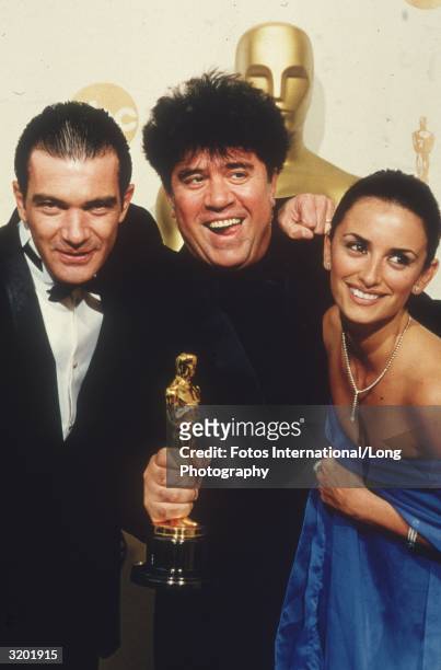 Spanish actors Antonio Banderas and Penelope Cruz stand with Spanish director Pedro Almodovar, who holds the Oscar he won for Best Foreign Film for,...