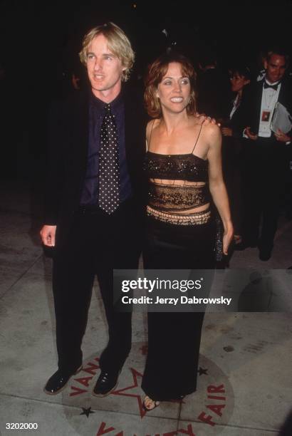 American rock musician Sheryl Crow, wearing a black spaghetti strap top and full length skirt, poses with her boyfriend, actor Owen Wilson, at the...