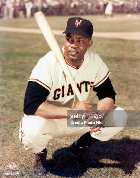 Outfielder Monte Irvin of the New York Giants poses for a portrait, crouching and holding a baseball bat, 1950s. Irvin played for the Giants from...