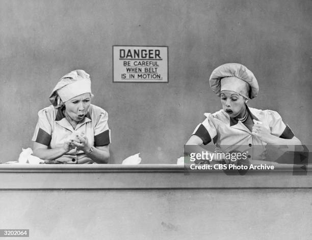 American actresses Vivian Vance , as Ethel Mertz, and Lucille Ball , as Lucy Ricardo, work side-by side at a candy factory conveyor belt in an...