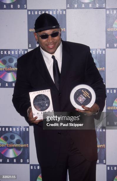 Rap vocalist LL Cool J smiles while posing with two awards backstage at the 6th Annual Blockbuster Entertainment Awards, Shrine Auditorium, Los...