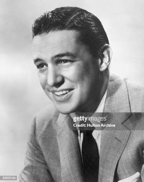 Studio portrait of broadcast journalist Mike Wallace smiling.