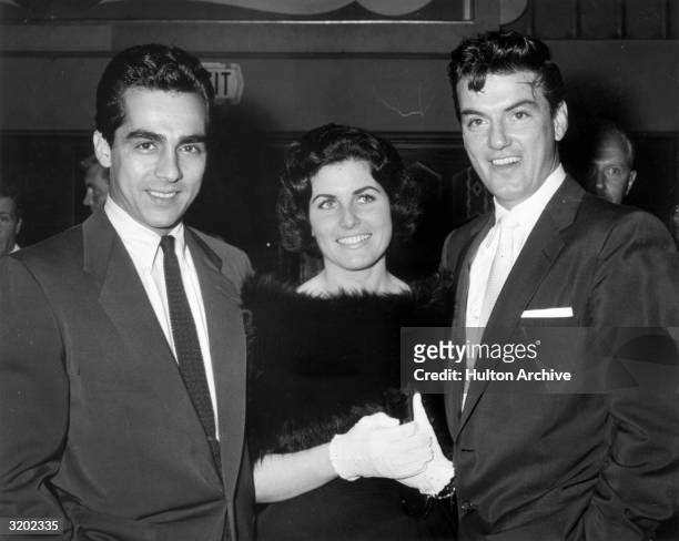 American actor William Campbell and his first wife, Judith Exner, pose with Parry Lopez at the premiere of director Jesse Hibbs' film, 'To Hell and...