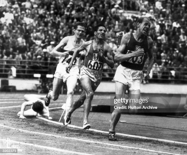 With his trademark grimace, Emil Zatopek of Czechoslovakia charges to the lead entering the homestretch of the 5,000 meters final at the 1952 Olympic...