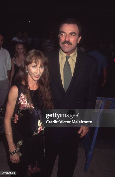 American actor Tom Selleck and his wife, Jillie Mack, attend an unidentified event in New York City. Selleck is wearing a black suit over a yellow...