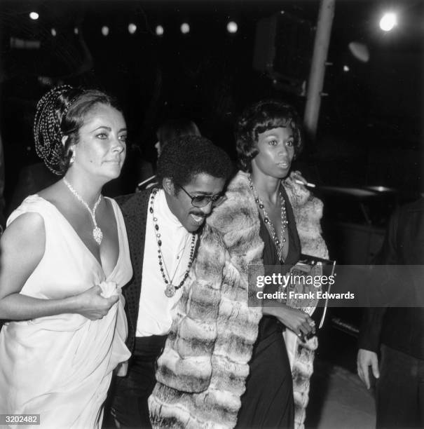 British-born actor Elizabeth Taylor, American entertainer Sammy Davis Jr. And his wife, Altovise Gore, attend the premiere of director Jack Haley...