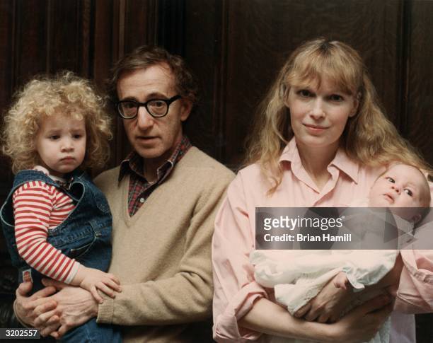Portrait of American film director and actor Woody Allen and his girlfriend, American actor Mia Farrow, posing with their daughter, Dylan , and their...