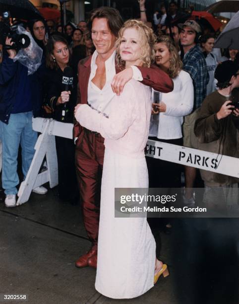 Full-length image of married American actors Kevin Bacon and Kyra Sedgwick attending the premiere of director John Turteltaub's film, 'Phenomenon,'...