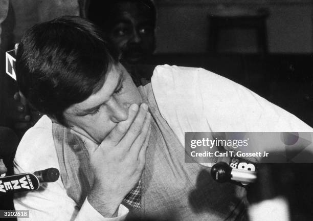 American baseball player Tom Seaver, wearing shirt sleeves, closes his eyes and holds his hand to his mouth after becoming emotional during a press...