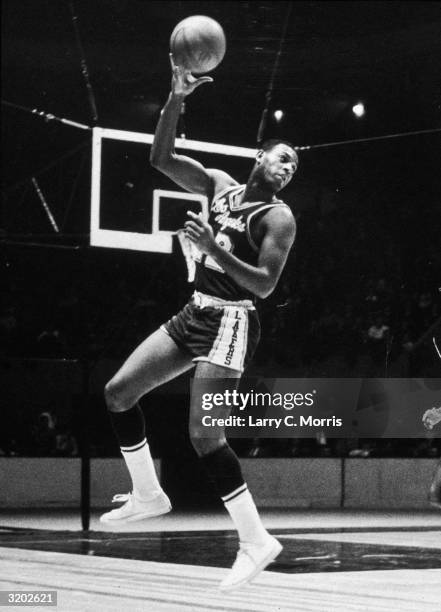 Full-length image of Los Angeles Lakers basketball player Elgin Baylor preparing to make a long over-the-shoulder pass during an NBA game against the...