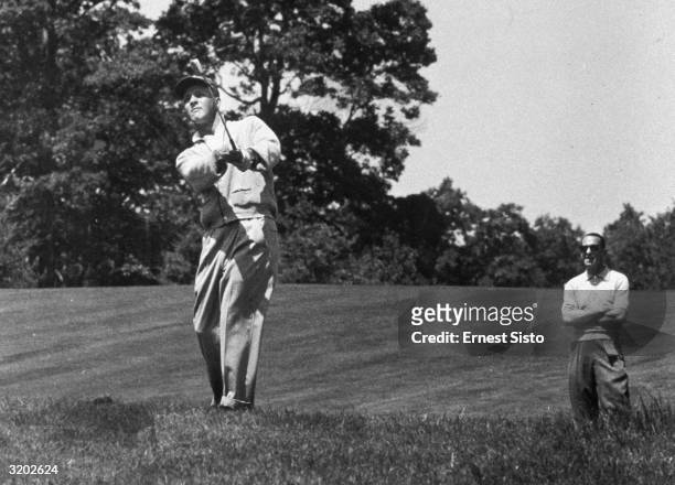 Full-length image of American professional golfer Arnold Palmer making a shot on the fairway of the fifteenth hole while competing in the Pepsi Golf...