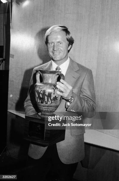 Professional American golfer Jack Nicklaus poses with a Grecian trophy chalice after being honored as Sportsman of the Year by 'Sports Illustrated'...