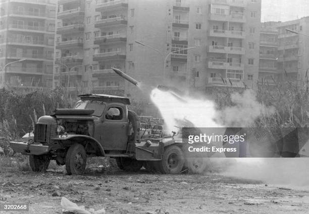 Katyusha rocket is fired from the back of an army truck into an apartment complex during the Lebanese Civil War, Lebanon, probably 1975. The war,...