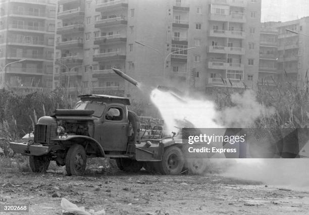 Katyusha rocket is fired from the back of an army truck into an apartment complex during the Lebanese Civil War, Lebanon, probably 1975. The war,...