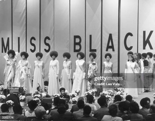 Contestants for the Miss Black America pageant line up on stage in front of a panel of judges during the evening gown competition.