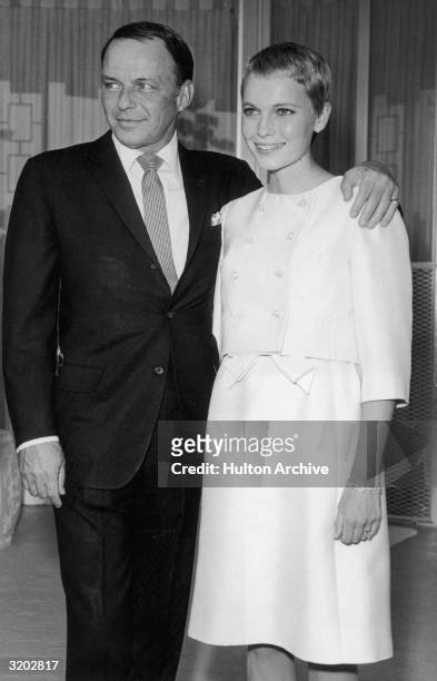 American singer Frank Sinatra stands with his arm around his third wife, actor Mia Farrow, during their private wedding in Las Vegas, Nevada. Sinatra...