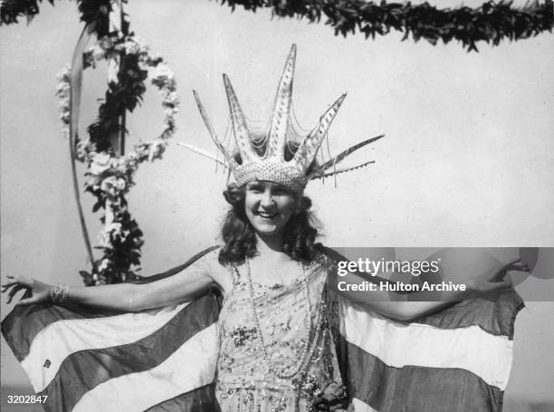 Margaret Gorman from Washington D.C. Smiles, wearing a large Statue of Liberty crown and a striped cape, as the first Miss America, Atlantic City,...