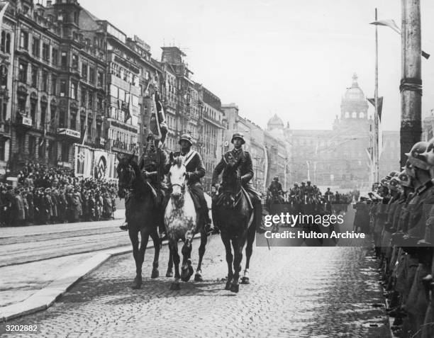 Full-length image of German troops riding on horseback during a parade through Prague shortly after the Nazi takeover of Czechoslovakia and the...