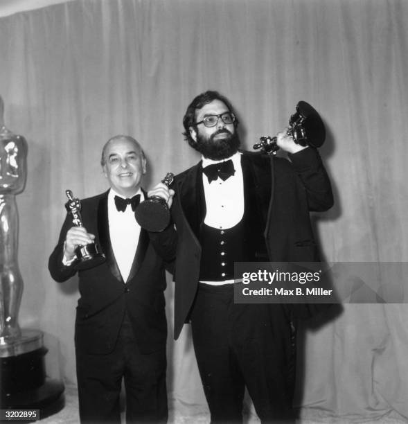 Portrait of American director Francis Ford Coppola with his father, Carmine, holding three of the six Academy Awards won by, 'The Godfather Part II,'...