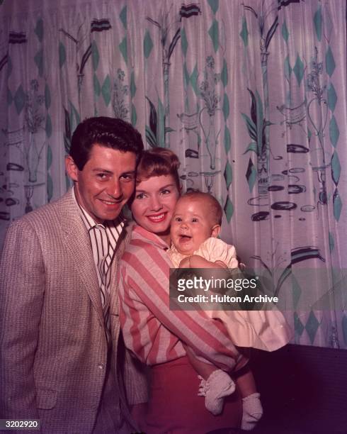 Family studio portrait of married American singer/actors Eddie Fisher and Debbie Reynolds with their daughter Carrie Fisher.