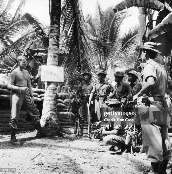 British officer, Major James W Loe of Edinburgh's Royal Regiment of Havant briefing one of his platoons for a sortie against Indonesian guerillas in...