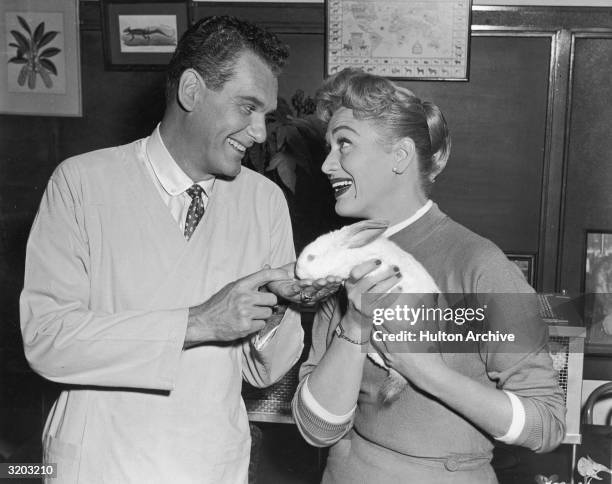 Still from the television program, 'Our Miss Brooks,' with American actors Robert Rockwell and Eve Arden holding a white bunny.