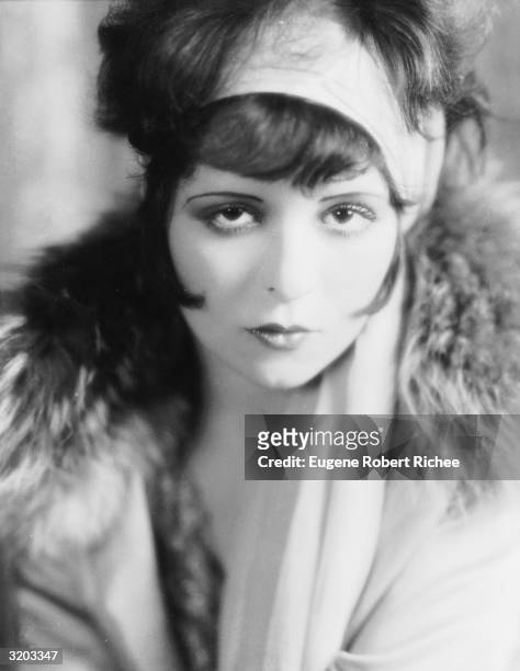 Original 'It Girl', Clara Bow in headscarf and fur-trimmed coat.