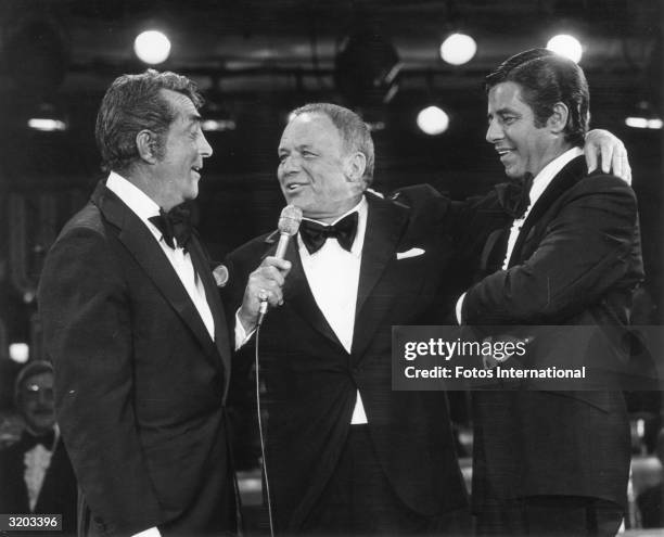 American actors and singers Dean Martin and Frank Sinatra, and American actor and comedian Jerry Lewis perform on stage during the eleventh annual...